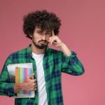 front-view-young-guy-pondering-about-something-with-notebooks